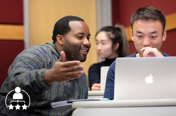 two people talking over a laptop