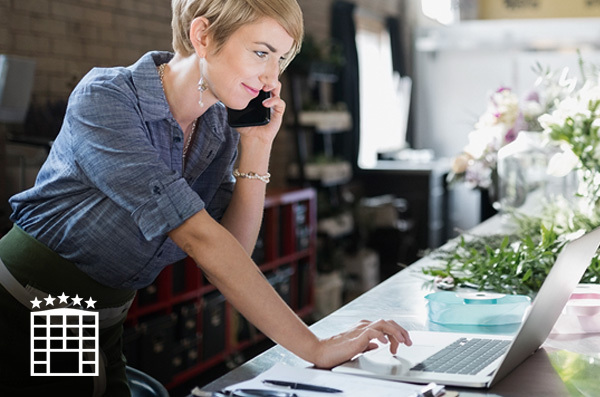 woman talking on the phone and working on a laptop